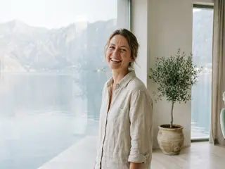 A laughing woman with a natural smile in the bright practice overlooking the sea.